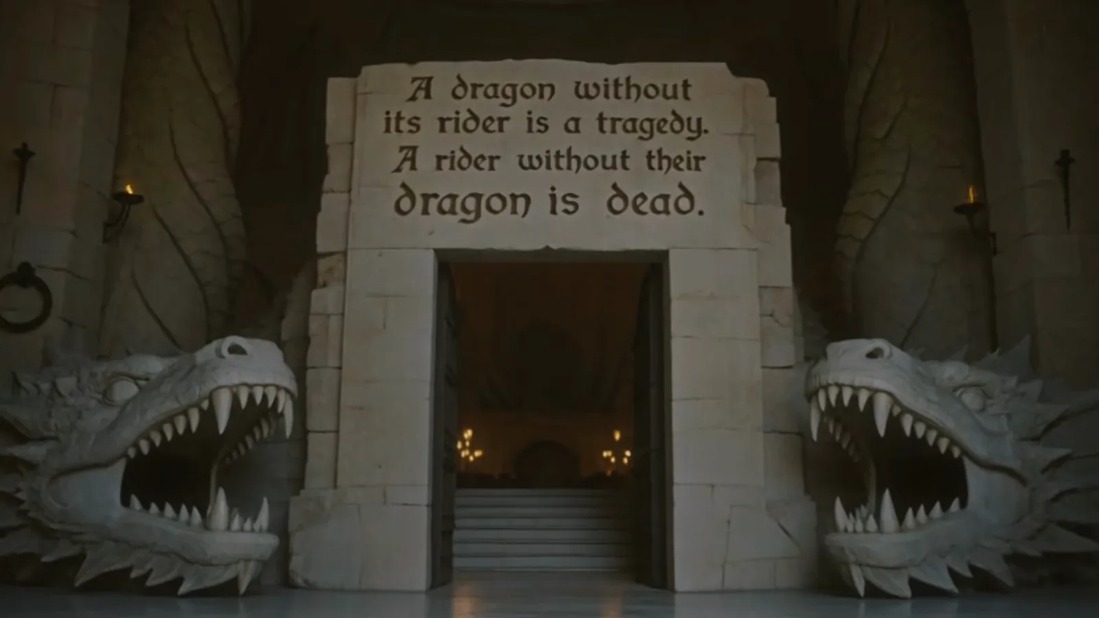 Stone gateway flanked by two carved dragon-head statues, with the Dragon Rider Codex first law — a dragon without its rider is a tragedy — carved above the entrance