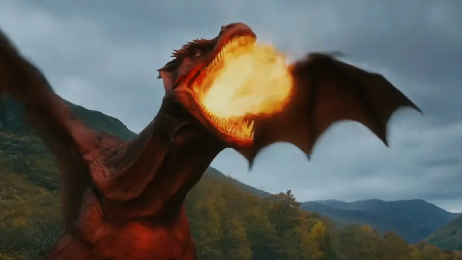A red dragon breathes a wave of fire across a forested valley while cadets scatter during the Threshing